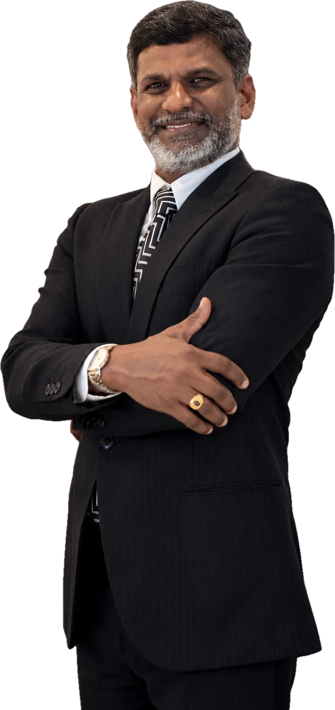 Prof. Sivarao Subramonian smiling with his arms crossed, in a dark pinstripe suit