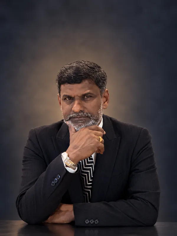 Studio portrait of Prof. Sivarao Subramonian seated, chin resting on his hand